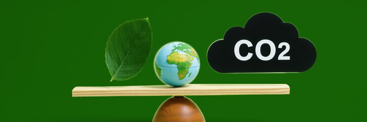 Green leaf globe and carbon dioxide balanced on a scale Green leaf globe and carbon dioxide balanced on a scale
