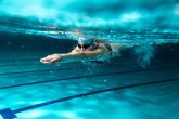 Freizeitbad Oktopus Schwimmerin mit Badekappe und Taucherbrille unter Wasser