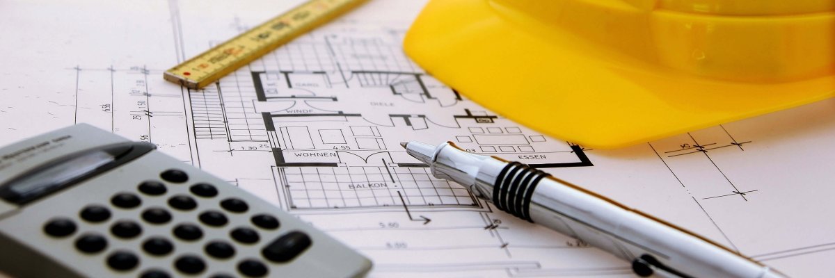 Stadtpläne mit Taschenrechner und Schutzhelm